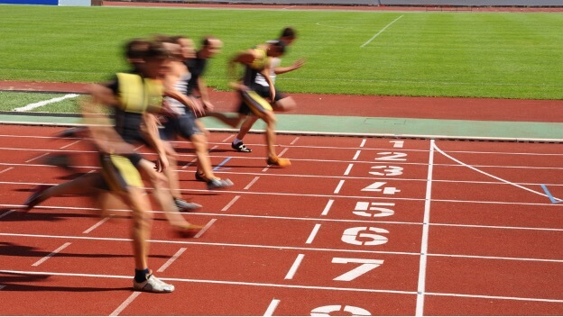 track runners crossing the finish line