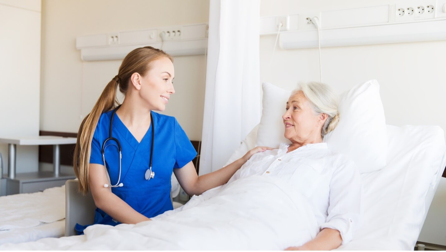 a nurse consoling an elderly patient