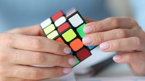 a woman working on a rubiks cube