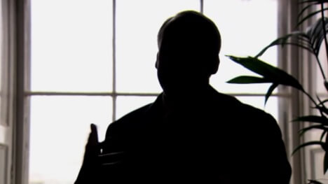 the silhouette of a man speaking