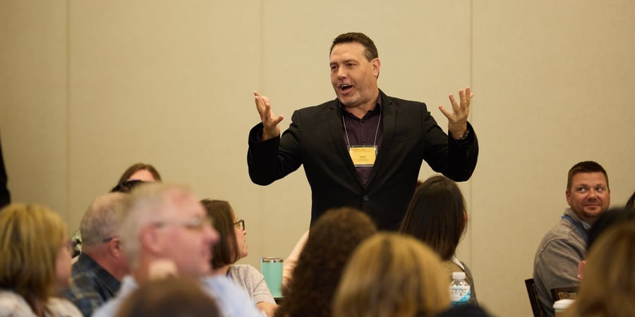 Blog Post Hero: Trainer engaging attendees at their tables during a Creative Training Techniques Conference session